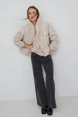 Chaqueta de piel sintética en color burdeos, con cuello alto y cierre frontal oculto. Presenta un diseño de corte recto y mangas largas con puños ligeramente ajustados.