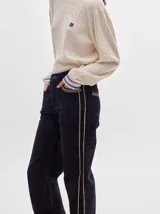 Pantalón de pana roja con corte holgado y tiro medio. Presenta una línea dorada a lo largo de la pierna.