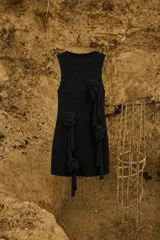 Vestido corto sin mangas de tejido de punto con lúrex, cuello a la base y apliques decorativos en forma de flores a lo largo de la prenda.