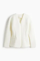 Blazer de mujer confeccionado en tejido efecto neopreno, en color blanco. Cuenta con cuello en V profundo, sin solapas, cierre frontal con broche a presión oculto, hombros caídos, mangas largas y bolsillos laterales de ojal simulados.