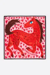 Pañuelo cuadrado de poliéster reciclado con fondo rosado, estampado de corazones rojos y un gran caballo rojo con detalles en marrón, y borde negro. Incluye la inscripción de la marca.
