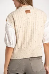 Chaleco de punto con textura trenzada, color beige melange, de cuello redondo y corte al cuerpo.