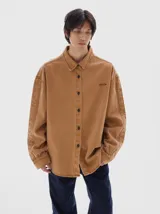 Camisa de denim de manga larga, color marrón lavado, con cuello clásico y botones negros. Corte ajustado.