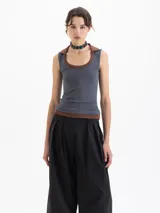 Musculosa de calce al cuerpo con cuello redondo y diseño de doble capa en el escote y ruedo, combinando tonos gris azulado y marrón.