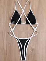 Trikini de diseño moderno en color negro con bordes en contraste blanco. Presenta corpiño triangular y bombacha de tiro alto unidos por tiras laterales finas y ajustables.