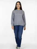 Buzo de punto color gris, con cuello redondo y diseño de textura sutil en la parte superior. Presenta mangas largas con puños acanalados y ruedo también acanalado, con un corte recto y holgado.