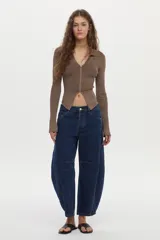 Cardigan tejido en rib con hilado de lurex, color crudo, calce al cuerpo, cuello polo, mangas largas con aberturas y cierre metálico frontal bidireccional.