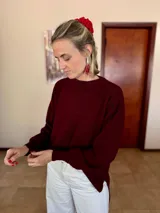 Sweater de punto acanalado color bordó, con cuello redondo, mangas largas con puños ajustados y diseño holgado con tajos laterales en el ruedo.