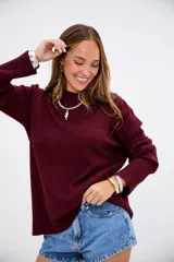 Sweater de tejido de punto acanalado en color bordó, con cuello redondo y mangas largas. Presenta un corte holgado y cómodo.