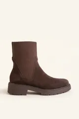 Bota tipo chelsea de gamuza color marrón, con paneles laterales elásticos acanalados y suela de goma track con taco bajo.
