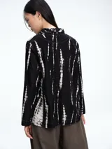 Chaqueta de corte recto y silueta cómoda, con cierre frontal de botones y bolsillos delanteros. Presenta un diseño estampado con efecto tie-dye en tonos negro y blanco.