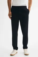 Jogger de vestir slim fit color azul marino, con pliegues adelante y atrás, elástico revestido con cordón ajustable en la cintura y bolsillos al bies.