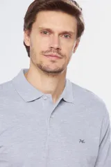 Remera polo de manga corta en tejido piqué color celeste. Presenta cuello clásico con botones, bordado pequeño en el pecho y detalles en tela oxford en el interior del cuello.