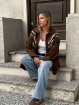 Saco marrón de lana con cuello camisero, cierre con botones y detalle de crochet en los hombros.