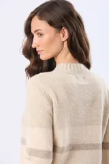 Buzo tejido de abrigo con cuello redondo y diseño a rayas horizontales en tonos suaves de beige y gris.