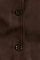 Abrigo largo hasta la rodilla, color marrón oscuro, con acabado cepillado suave. Presenta cuello camisero, manga raglán, botonadura frontal y bolsillos laterales insertados. Tiene forro interior y abertura en la espalda.