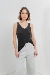 Musculosa tejida color amarillo pálido, con escote en V delantero y trasero.