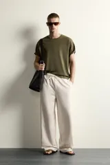Pantalón de corte wide fit confeccionado en algodón con interior de rizo. Presenta cintura elástica con cordón ajustable y bolsillos laterales.