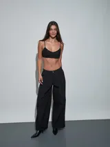 Top negro de tirantes finos con textura y apliques brillantes, escote redondo y diseño corto.