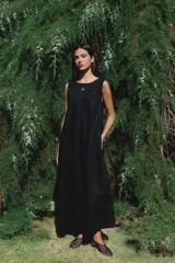 Vestido largo sin mangas de corte holgado, con cuello redondo y bolsillos laterales. Confeccionado en algodón, presenta un diseño minimalista y fluido.