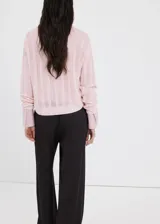 Chaleco de tejido de punto calado, color rosado, con diseño recto y cuello redondo.