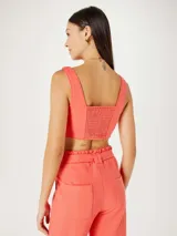 Top corto de escote cuadrado y tirantes anchos, con diseño entallado al cuerpo y costuras verticales decorativas.