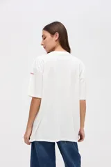 Remera de manga corta color azul, con calce clásico y tajos laterales. Presenta un bordado pequeño en el pecho con el texto 'UNIFORM STUDIO LAB' y un detalle bordado en la manga. Confeccionada en algodón lavado con textura suave.