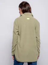 Campera polar color verde oliva, de corte largo, con cuello alto y cierre frontal. Tiene un bolsillo de nylon verde oscuro en el pecho y dos bolsillos laterales.