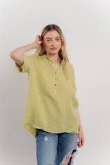 Blusa blanca de lino con escote en V abotonado y mangas cortas arremangadas.