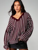 Sweater oversized de tejido de punto con diseño de rayas verticales en contraste, escote en V y mangas amplias con puños acanalados.