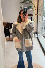 Campera de cuero genuino color gris con efecto desgastado, forro interno, solapas, puños y bolsillos frontales de corderito sintético en color beige.