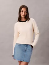 Remera de manga larga Calvin Klein confeccionada en tejido waffle de color beige, con cuello redondo y puños en contraste de color negro. Presenta un pequeño parche con el logo de la marca en el lateral inferior.