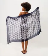 Pareo rectangular de playa en chiffon azul marino con estampado geométrico de lunares blancos, enmarcado por bordes y borlas en las esquinas.