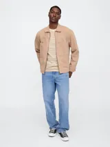 Remera de manga corta con cuello redondo, confeccionada en tejido de algodón con diseño de rayas horizontales finas en color marrón sobre fondo beige.