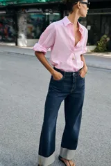 Jeans de tiro medio color azul oscuro, con cinco bolsillos, cierre de cremallera y botón. Presenta una silueta curvada, más ancha en el muslo y la rodilla, y un bajo con vuelta.