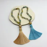 Japa Mala elaborado con 27 cuentas de piedra amazonita de 8 mm de diámetro, cuenta guru de Buda de metal y borla de hilo color crema.