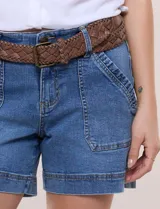 Short de denim azul con bolsillos frontales aplicados, pretina con pasadores, cierre y botón. Incluye un cinturón trenzado de cuero marrón.