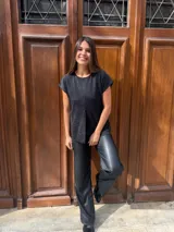 Blusa de lurex color negro con tajo en la parte delantera y mangas cortas.