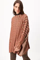 Sweater de tejido artesanal con diseño de rayas verticales en tonos camel y beige, corte holgado, cuello redondo y puños altos ajustados.