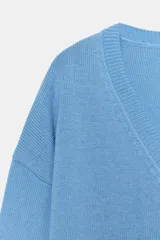 Sweater de punto color celeste, con escote en V y mangas largas con hombros caídos. Presenta terminaciones en rib en cuello, puños y ruedo.