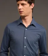Camisa de vestir masculina corte slim, color azul acero, con cuello inglés, manga larga y cierre frontal con botones. Confeccionada con tecnología Easy Care que aporta elasticidad y secado rápido.