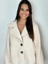 Chaqueta corta de paño color azul marino, con cuello solapa, cierre frontal de dos botones y mangas tres cuartos con diseño holgado.