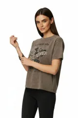 Remera de algodón con efecto gastado, color marrón oscuro, de corte holgado y manga corta. Presenta un estampado frontal con rosas y texto que incluye "ROSE POWER".