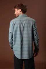 Camisa de hombre celeste con estampado de rayas horizontales en tonos azules y grises, de manga larga y cuello abotonado.