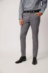 Pantalón de vestir color beige, confeccionado en algodón con spandex. Corte recto, con bolsillos laterales y traseros. Se ajusta a la cintura con cinturón de cuero trenzado en tonos azul y beige.
