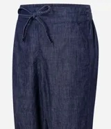 Pantalón de jeans de color azul oscuro, corte carrot (holgado en cadera y afunilado en pierna), con cintura alta ajustable mediante cordón.