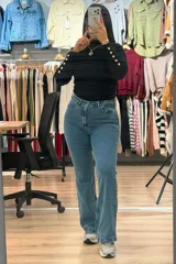 Jean de corte oxford con tiro alto, confeccionado en denim azul con efecto localizado. Presenta cierre frontal con botón y bolsillos laterales y traseros.