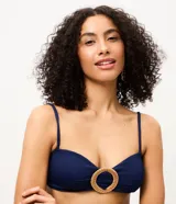 Top de bikini bandeau azul marino confeccionado en microfibra texturizada, con tirantes finos regulables y removibles. Cuenta con un aplique redondo de paja en el centro del busto y copas extraíbles.