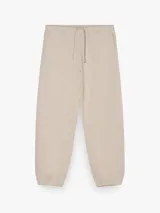 Pantalón jogger color beige, confeccionado en mezcla de algodón y poliéster, con cintura elástica ajustable mediante cordón y puños elásticos en los tobillos.