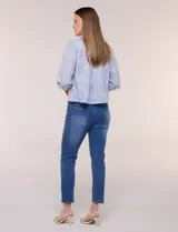 Blusa celeste de algodón con estampado floral, cuello mao fruncido con volado y cordel frontal con borlas. Tiene mangas largas abullonadas con puños elásticos y abotonadura frontal.